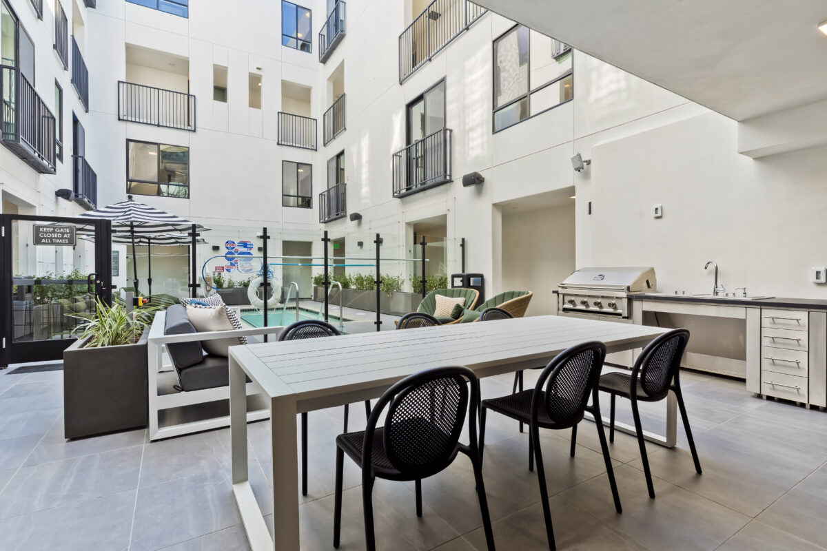 Other view of pool area with loungers, plants, and view of balcony