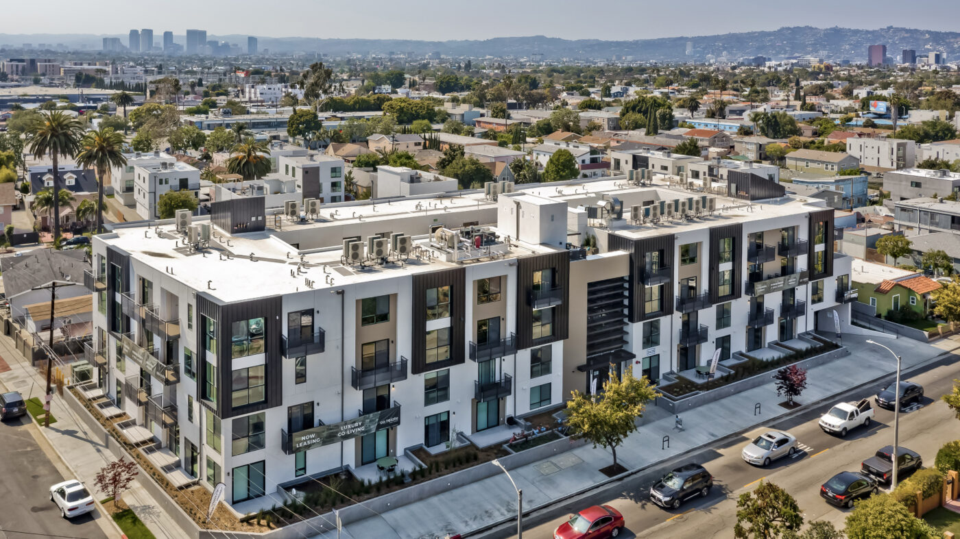 Aerial view of building showing surrounding streets with hills in the distance