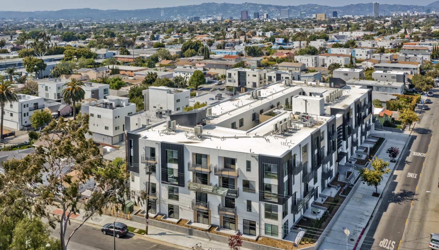 Aerial view of building showing surrounding streets with hills in the distance
