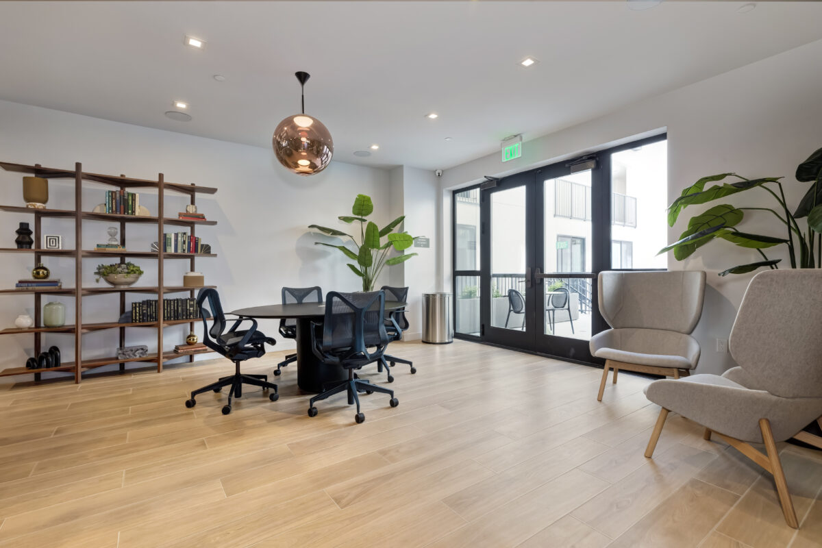 co-working area with tables, office chairs, and book shelf