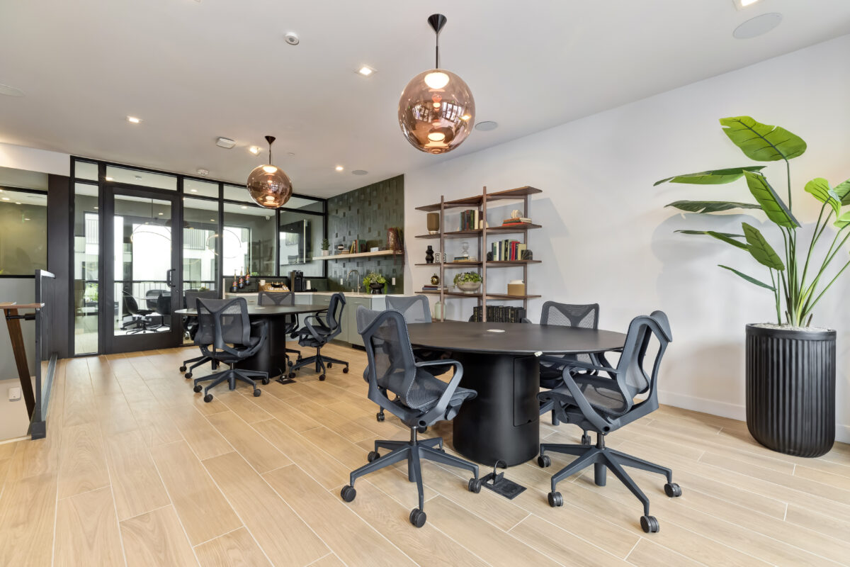 co-working area with tables, office chairs, and book shelf