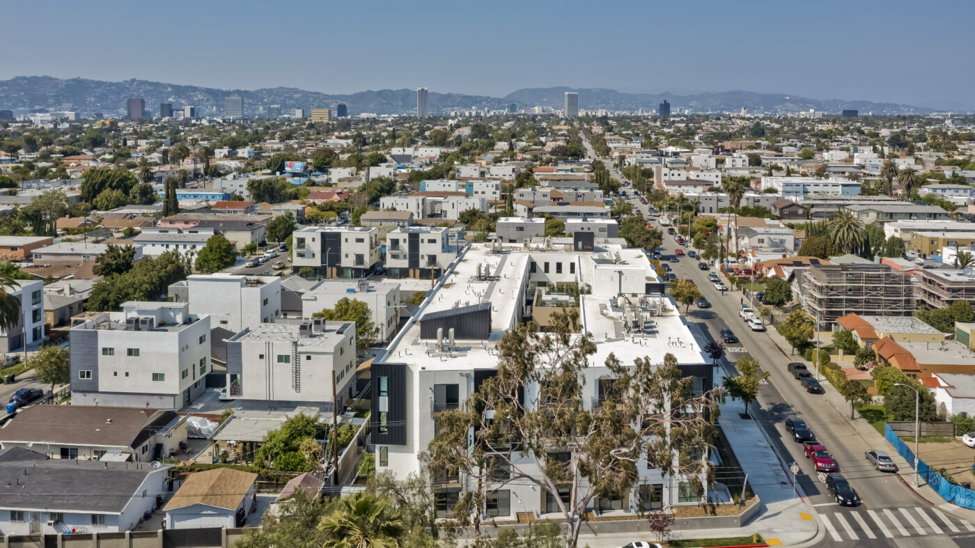 Aerial view of building showing surrounding streets with hills in the distance