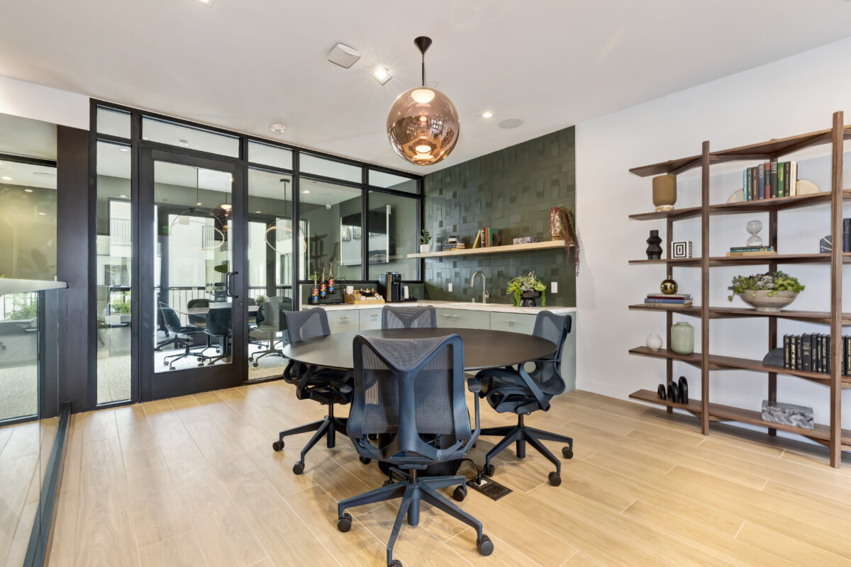 co-working area with tables, office chairs, and book shelf