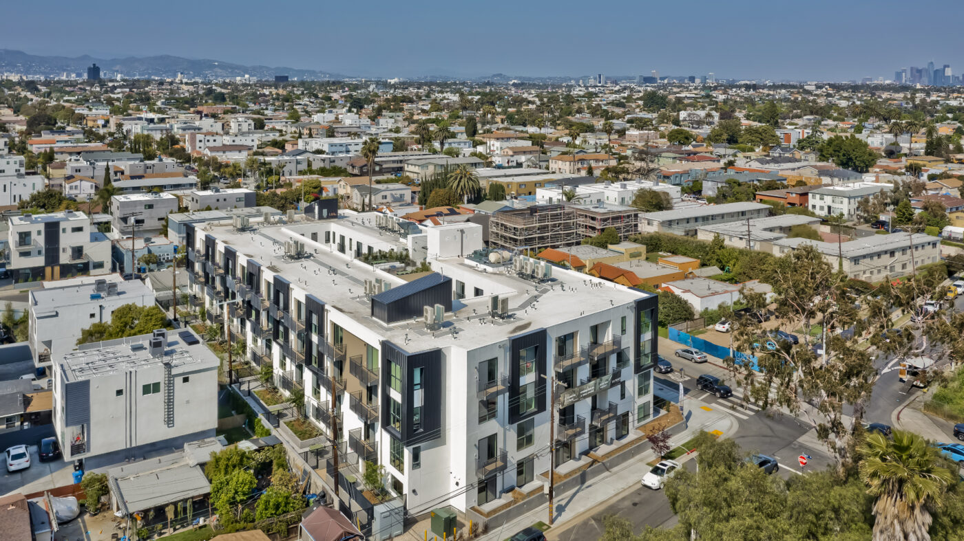 Aerial view of building showing surrounding streets with hills in the distance