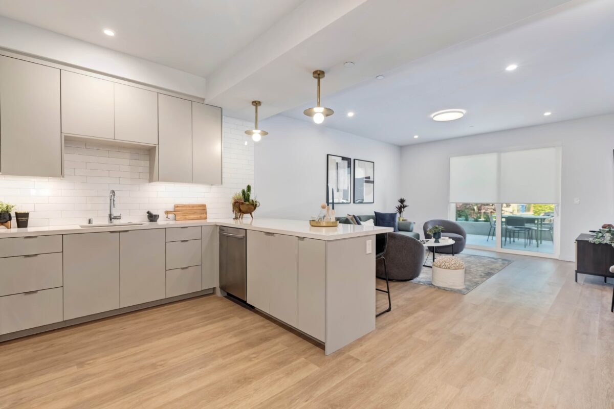 Open concept kitchen and living room with quartz counters and tile backsplash